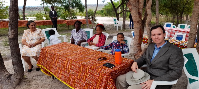 six people sitting at a table outdoors