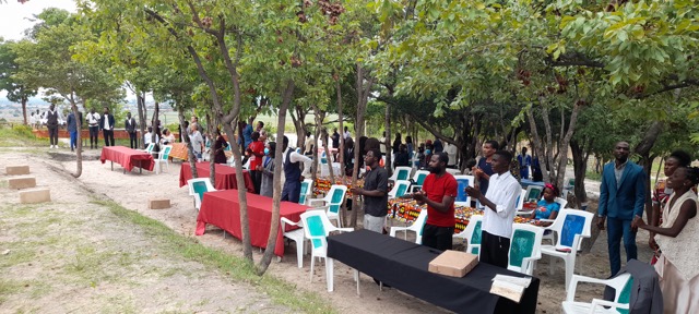 people standing and applauding at their tables at an outdoor wedding in menongue angola africa