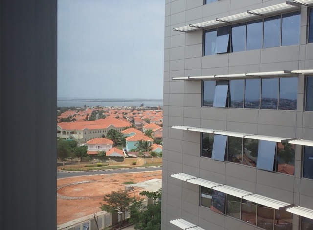 view of red-roofed homes and the ocean from a business park