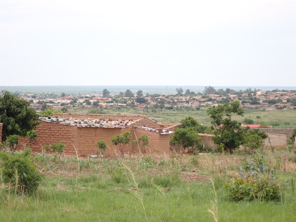 Mud brick structure with metal sheet roof held down by brick pieces