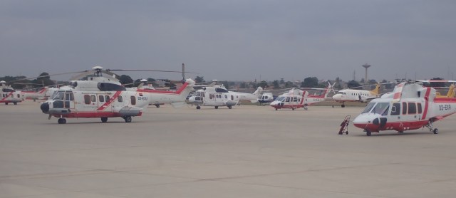 Helicopters and small planes parked on the tarmac at Luanda international airport