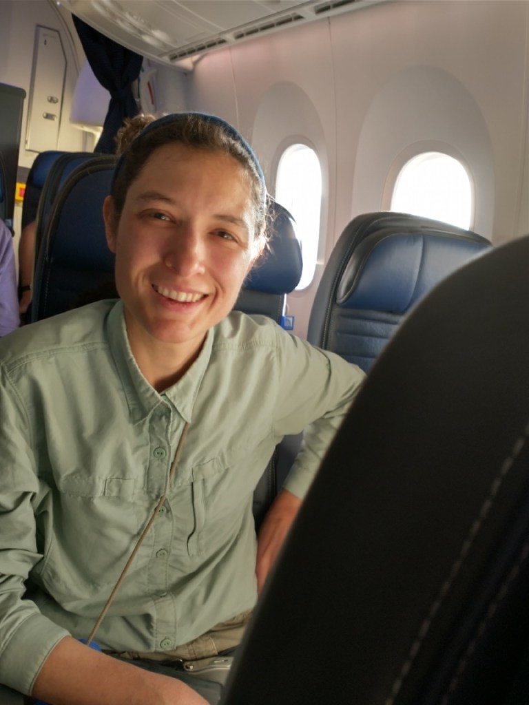 a woman sitting in an airplane seat smiles