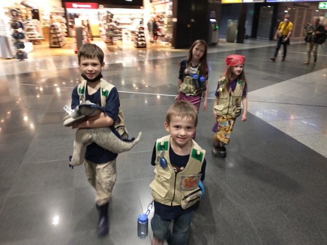 four children walk through an airport