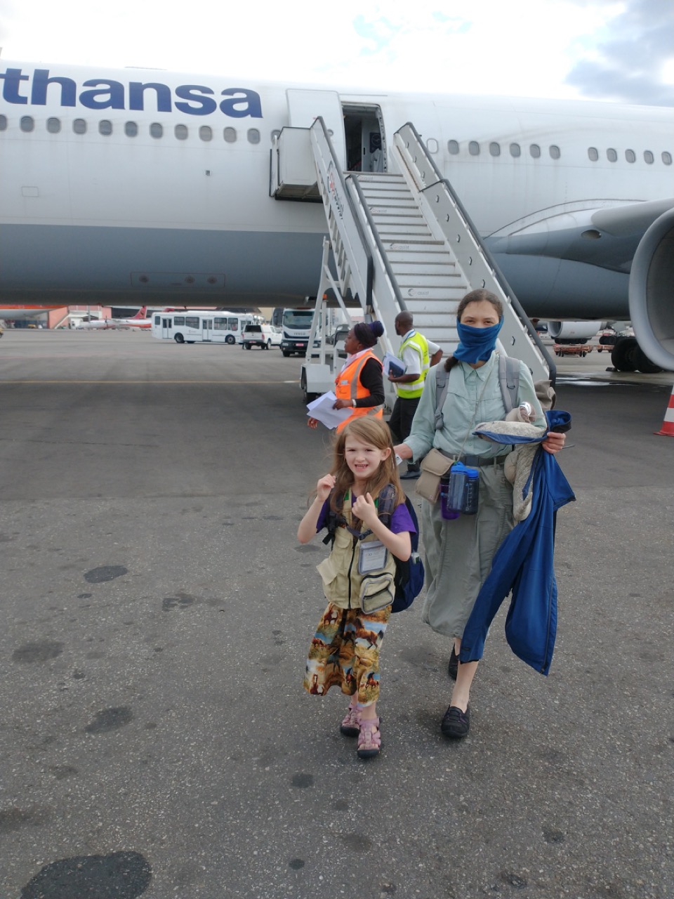 A woman and girl disembark a flight via stairs
