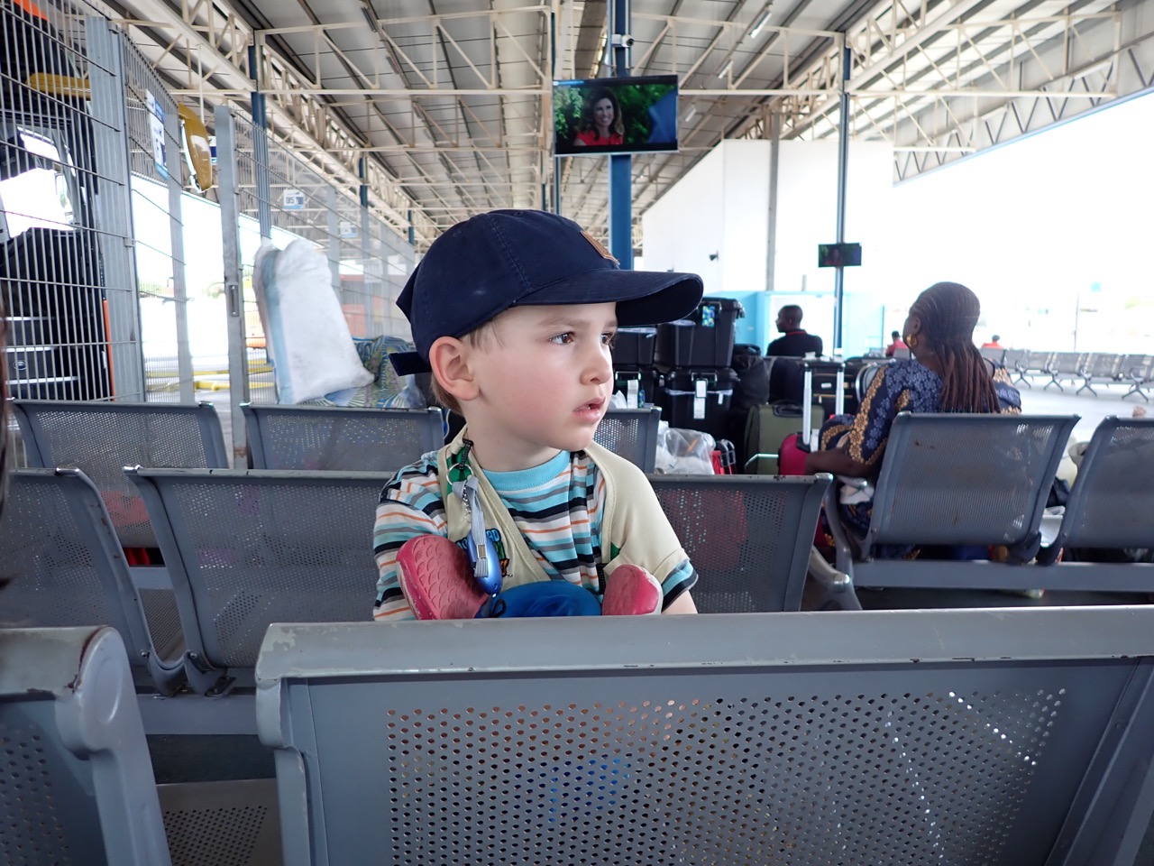 tired looking boy waiting at a bus station