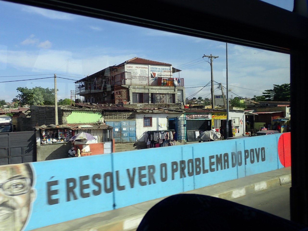 written portuguese statement on a wall in luanda saying, "is to solve the problem of the people"