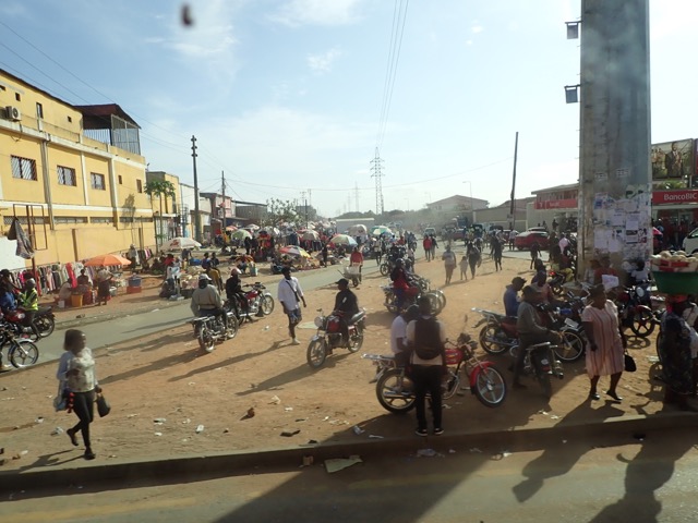 busy street in Luanda angola filled with pedestrians and motorcycles