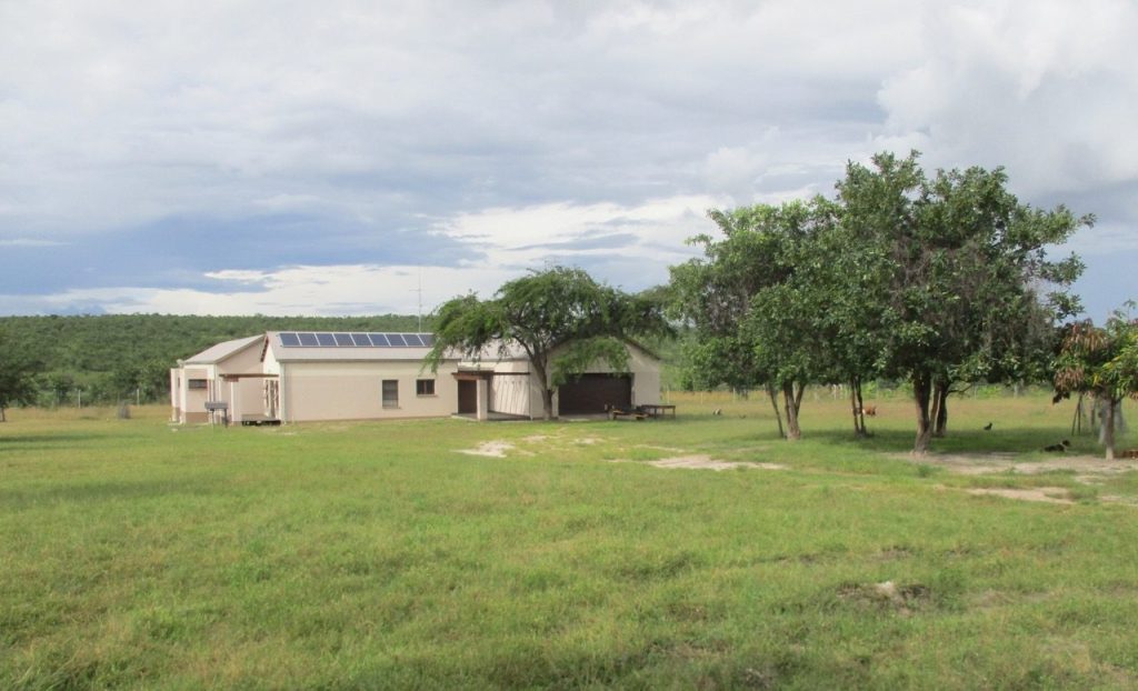 nice house in a green field surrounded by security fence